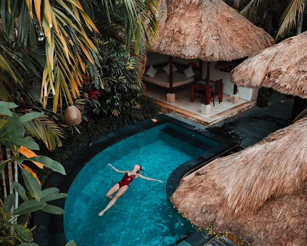 Woman floating in pool at resort