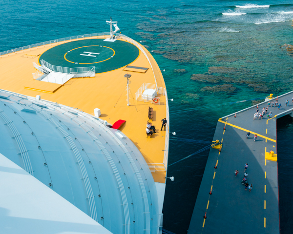 Cruise ship sailing through crystal-clear waters in Southeast Asia, showcasing stunning coastlines and tropical islands