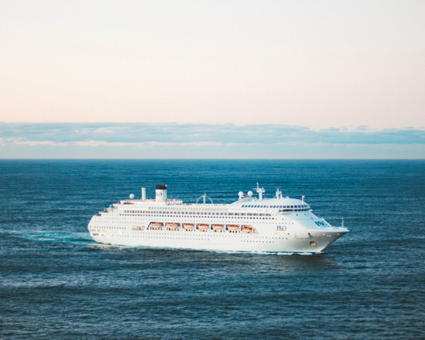 Cruise ship sailing through crystal-clear waters in Southeast Asia, showcasing stunning coastlines and tropical islands