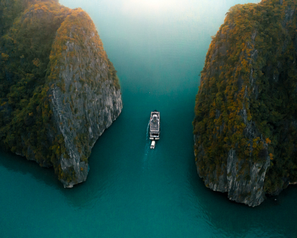 Cruise ship sailing through crystal-clear waters in Southeast Asia, showcasing stunning coastlines and tropical islands