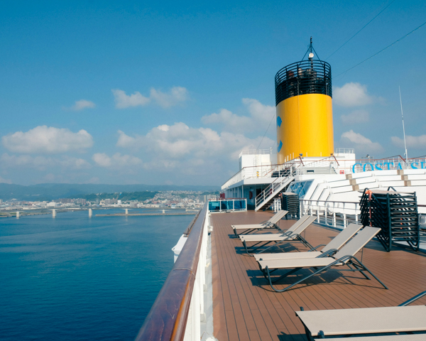 Cruise ship sailing through crystal-clear waters in Southeast Asia, showcasing stunning coastlines and tropical islands