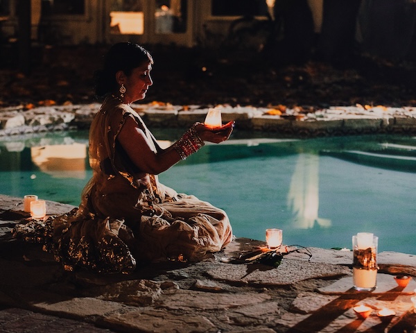 A vibrant Indian wedding celebration by the pool, adorned with Diwali lights and colorful decorations, radiating joy and festivity.