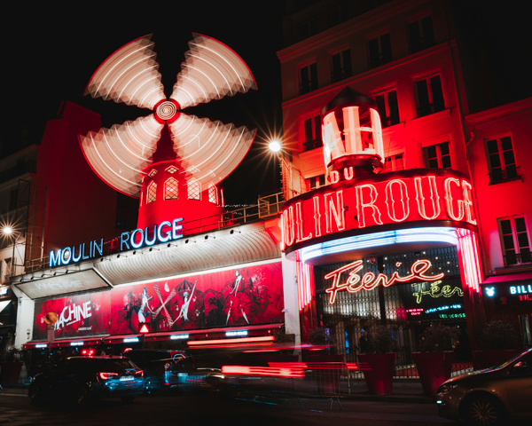 The famous Moulin Rouge in Paris, featuring its striking red and white facade, a symbol of entertainment and nightlife.