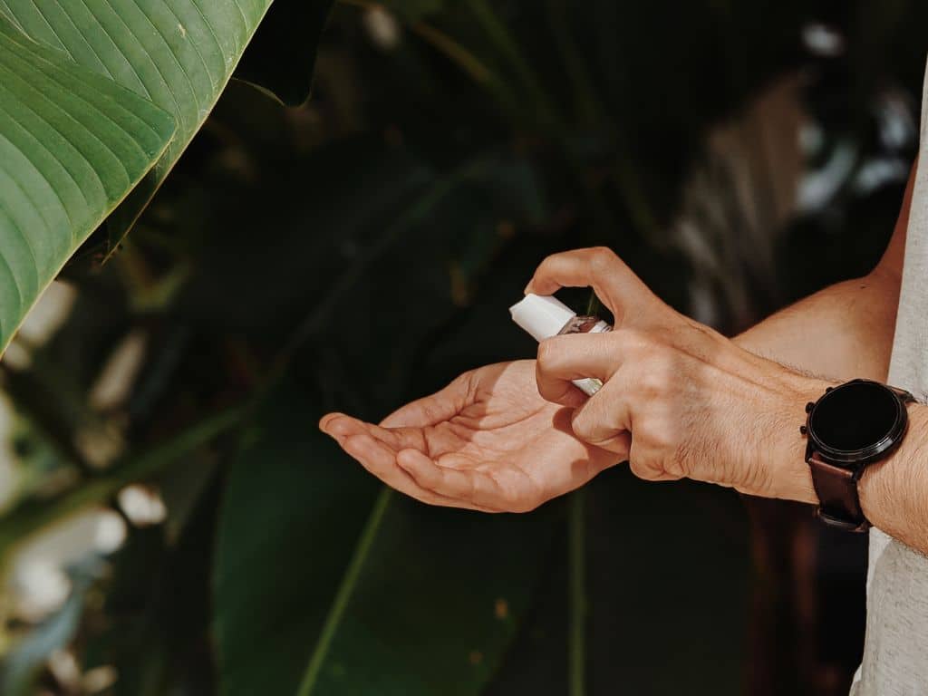 A man holds a bottle of hand sanitiser, ready to for cleanliness and hygiene.