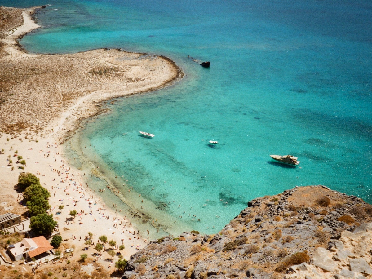 A beach in Malta with golden sand and turquoise waters, surrounded by rocky cliffs.