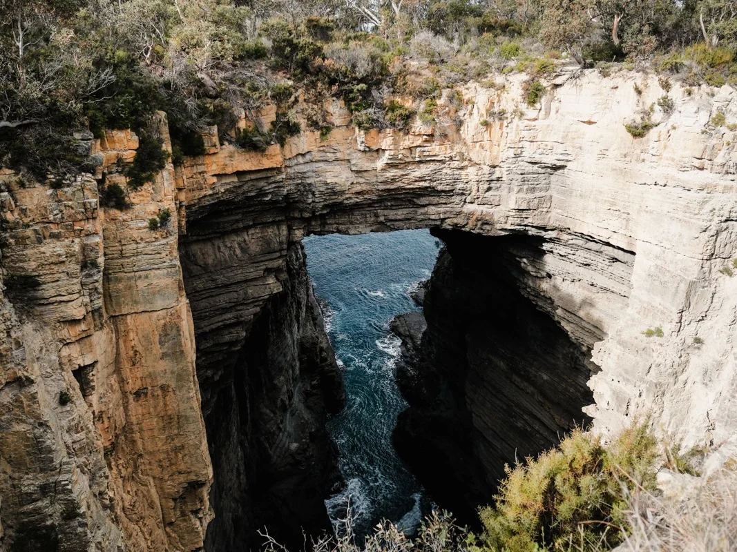 The Tasman Arch rock formation rising dramatically from the sea cliffs