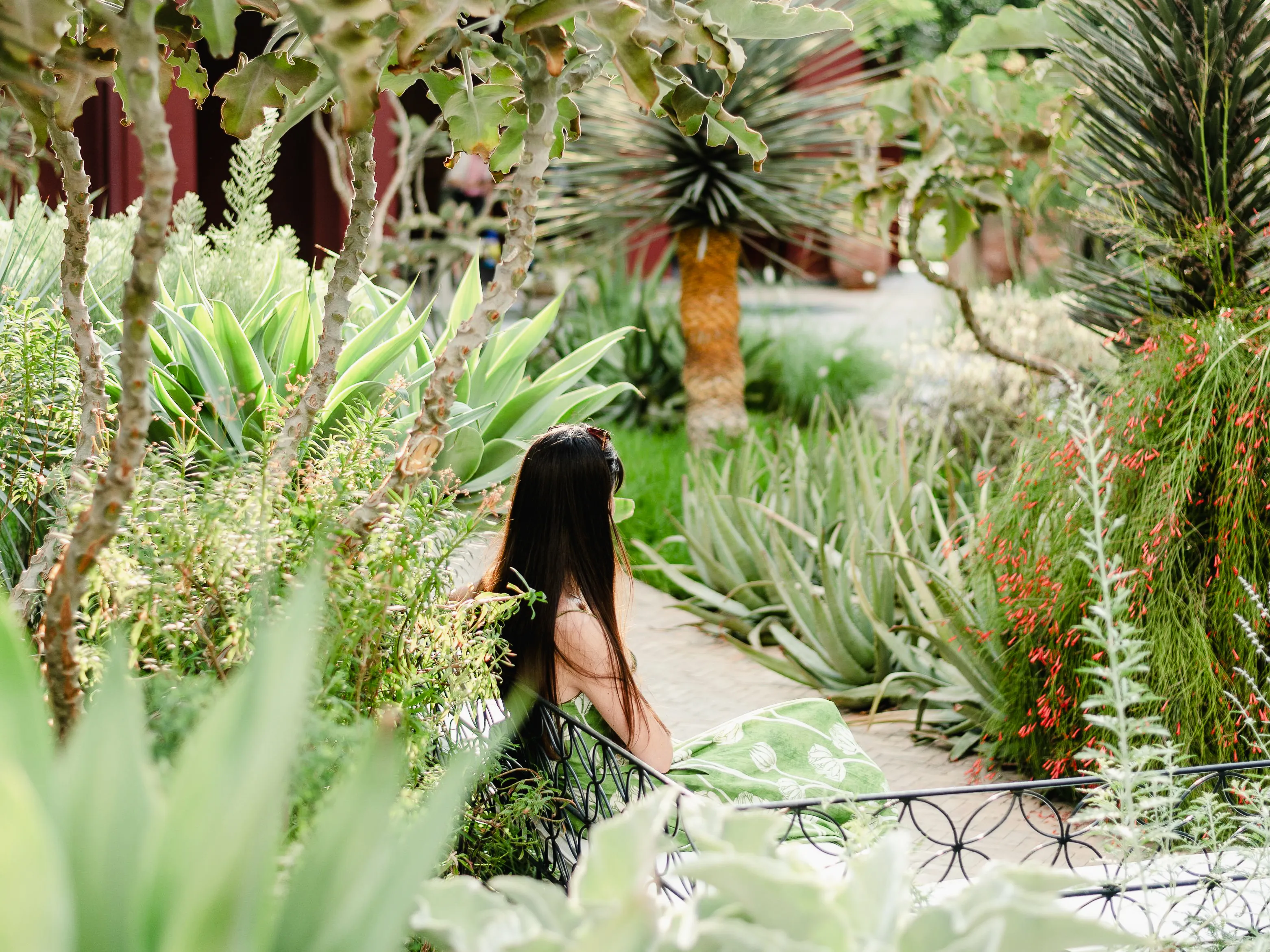 Visitor relaxing along a tropical garden walkway in Singapore surrounded by lush greenery.