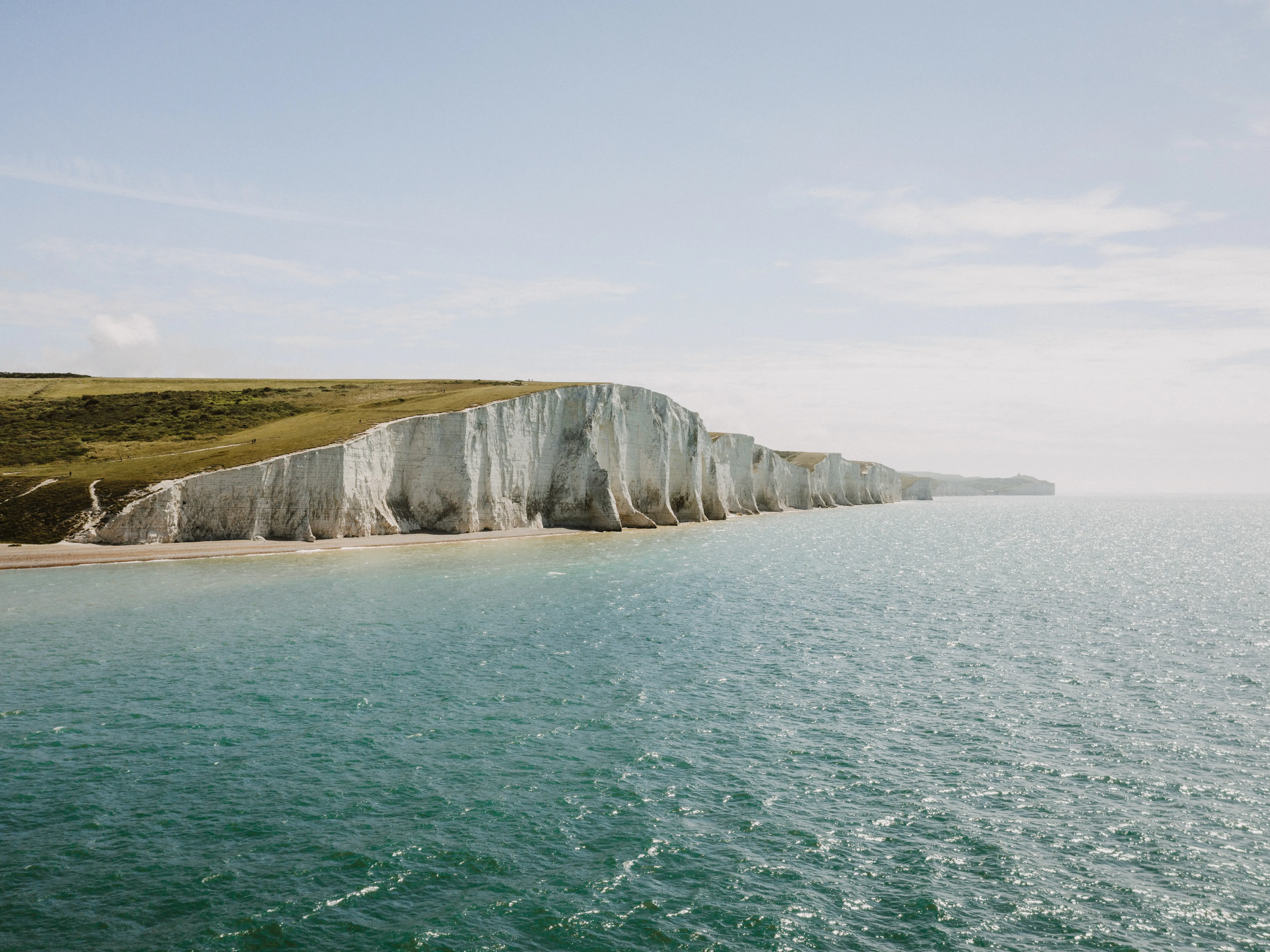 White chalk cliffs of the Seven Sisters coastline overlooking the sea, a scenic coastal day trip from London.
