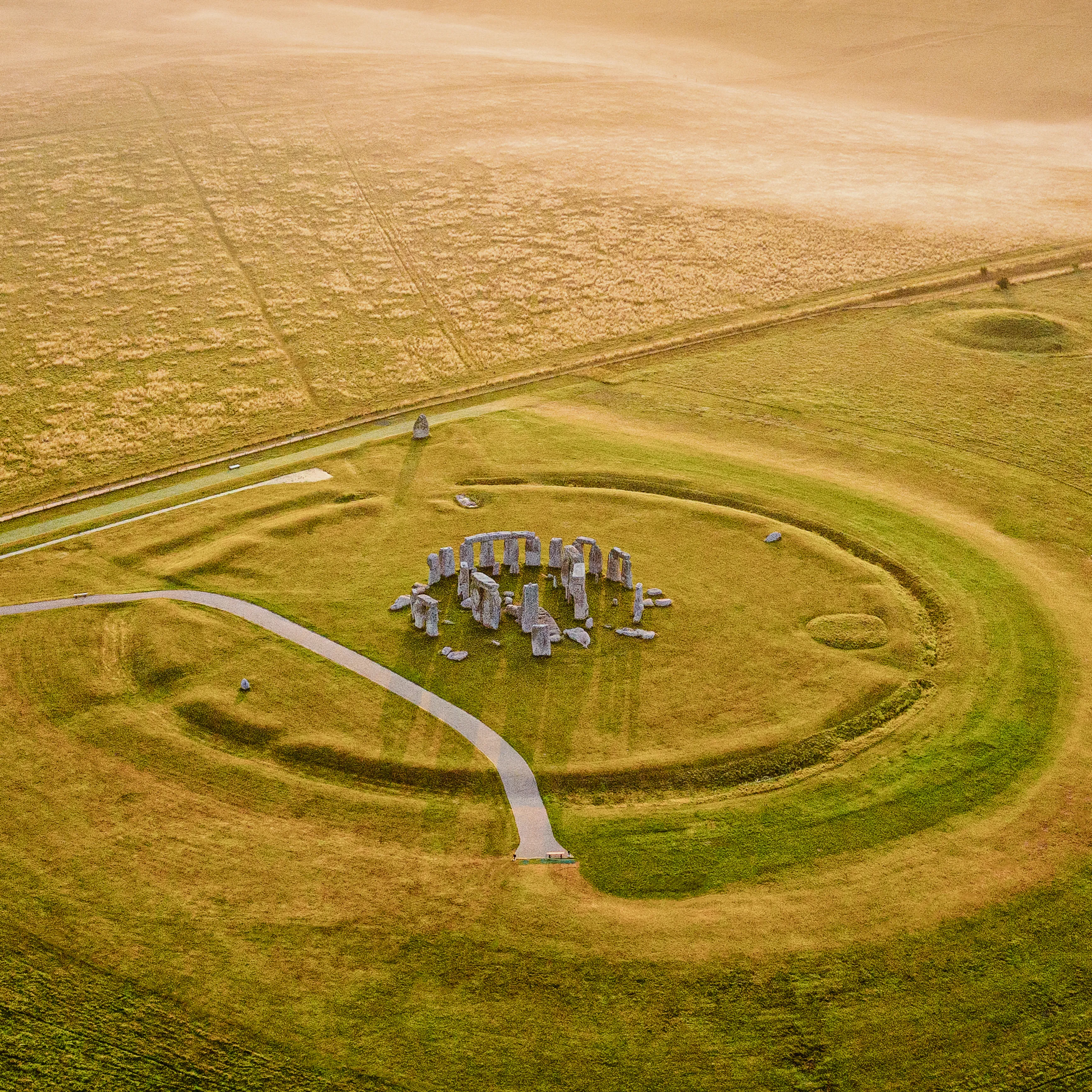 Aerial view of Stonehenge stone circle surrounded by open countryside in Wiltshire, a must-see day trip from London.