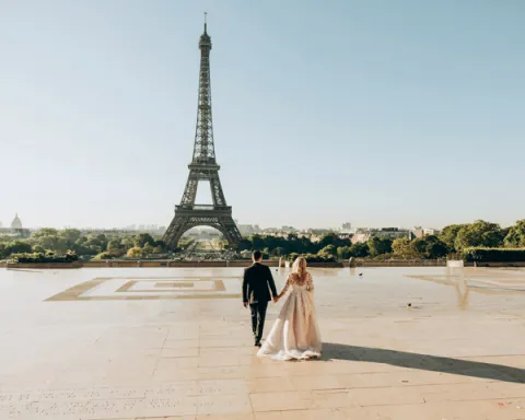 A couple poses for a wedding photo with the Eiffel Tower in the background, taken by a Paris wedding photographer.