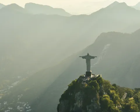 Aerial view of the Christ the Redeemer statue on Corcovado Mountain with soft sunrise light over the mountains in Rio de Janeiro, Brazil.