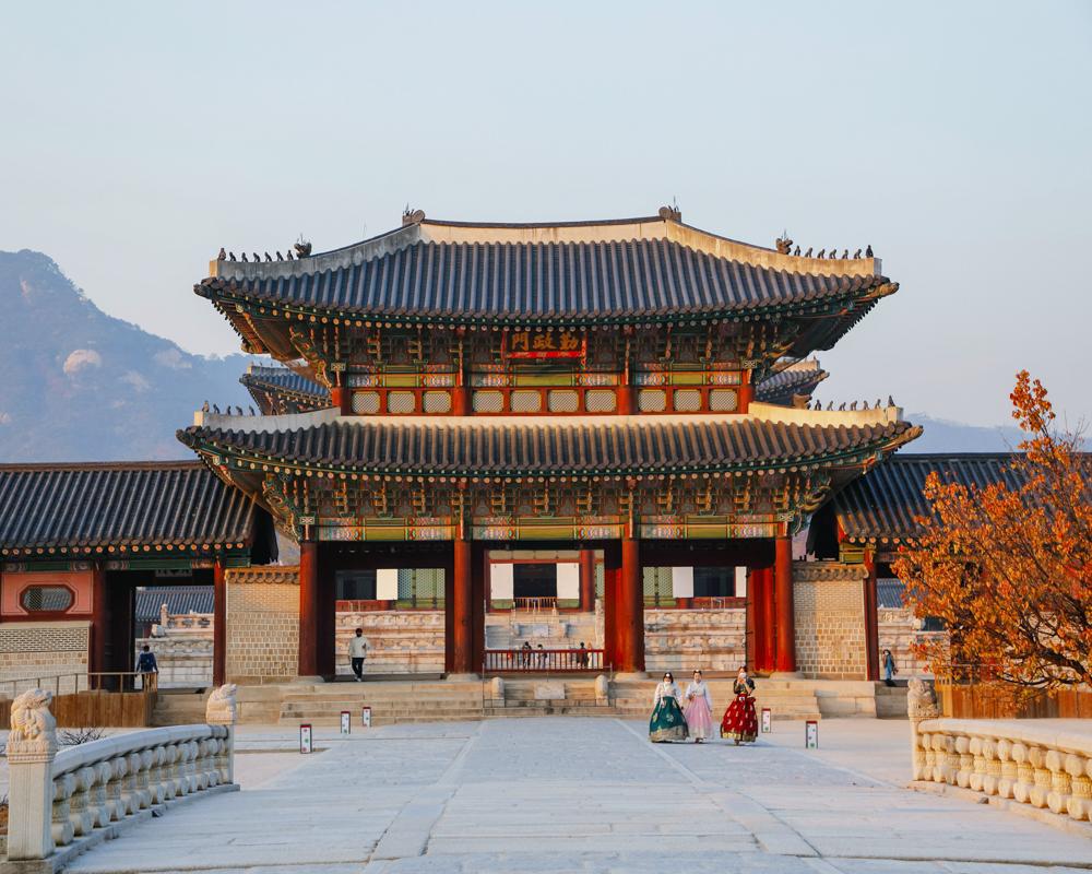Traditional Korean palace with ornate tiled rooftops and vibrant red columns